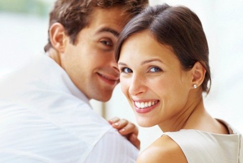 Beautiful young couple looking behind at you